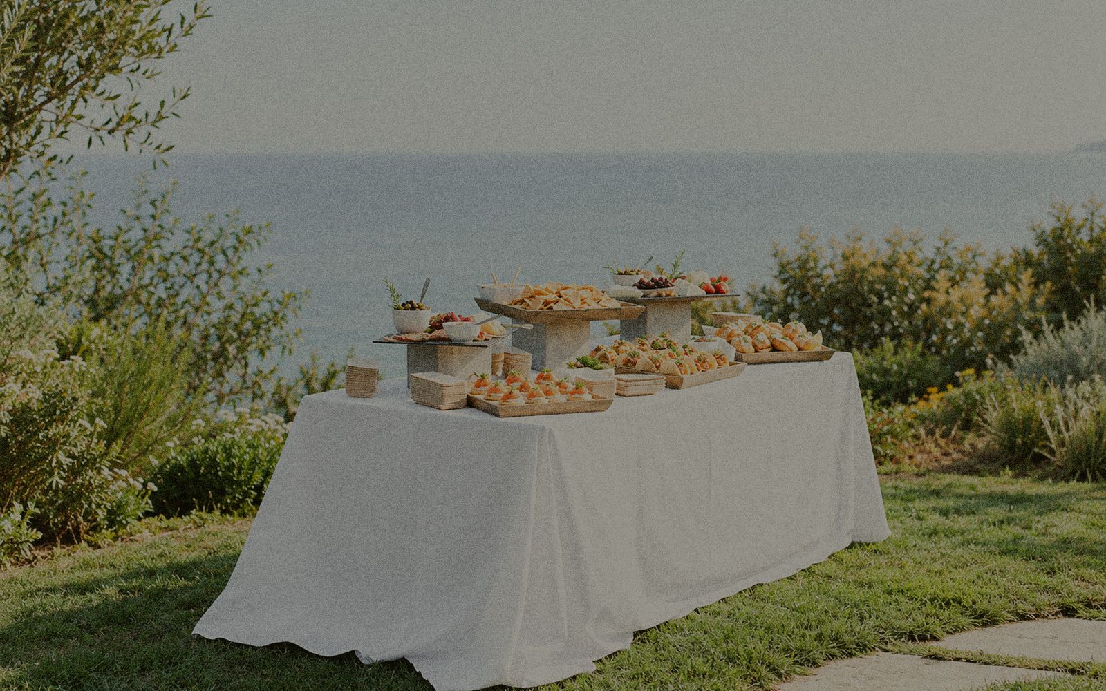 Buffet dressé sur une longue table nappée, face à la mer