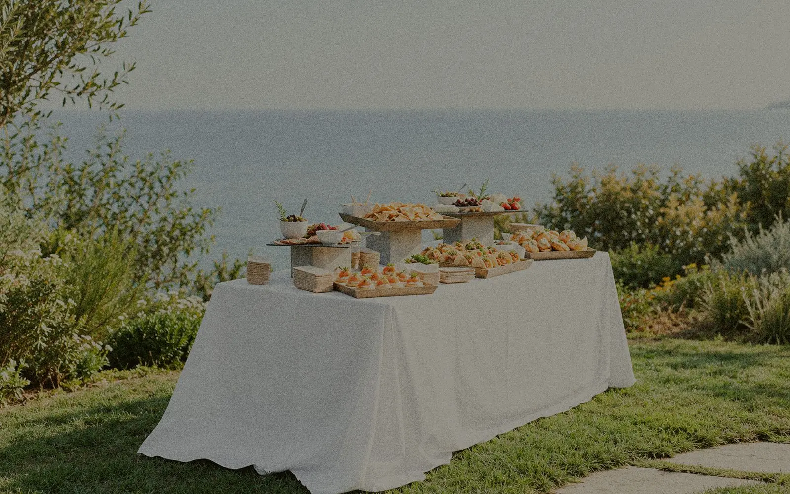 Buffet dressé sur une longue table nappée, face à la mer