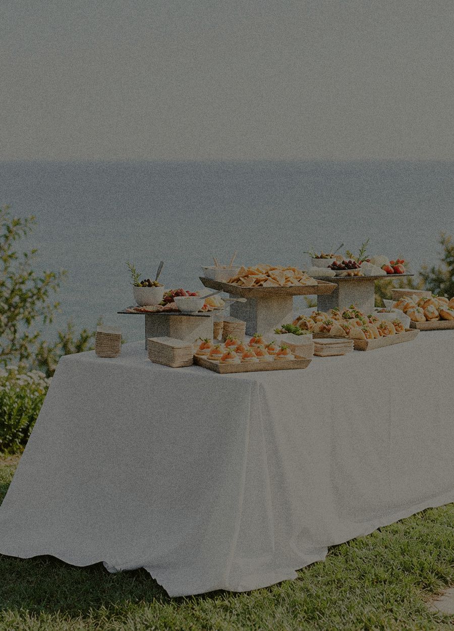 Longue table dressée face à la mer, buffet complet mis en place