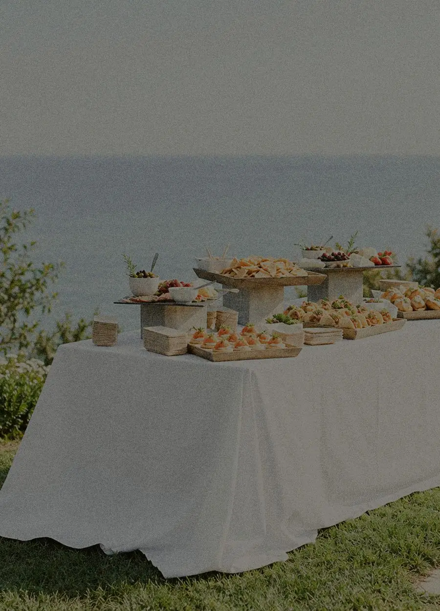 Longue table dressée face à la mer, buffet complet mis en place