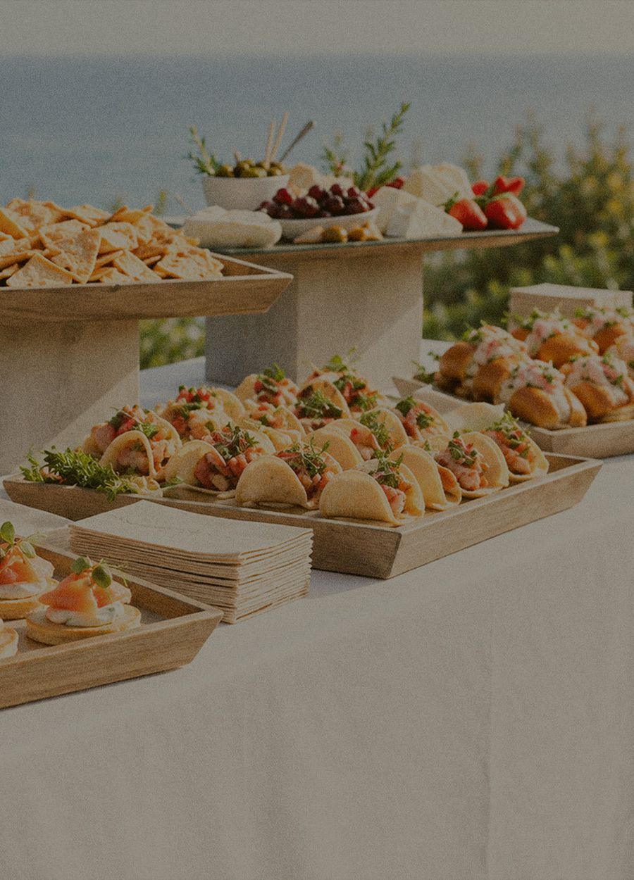Plateaux de bouchées et pièces salées dressés sur une grande tablée