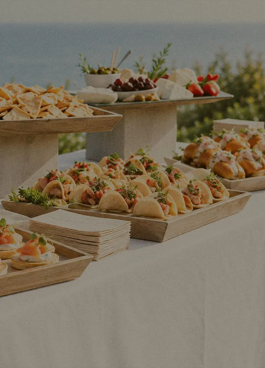 Plateaux de bouchées et pièces salées dressés sur une grande tablée