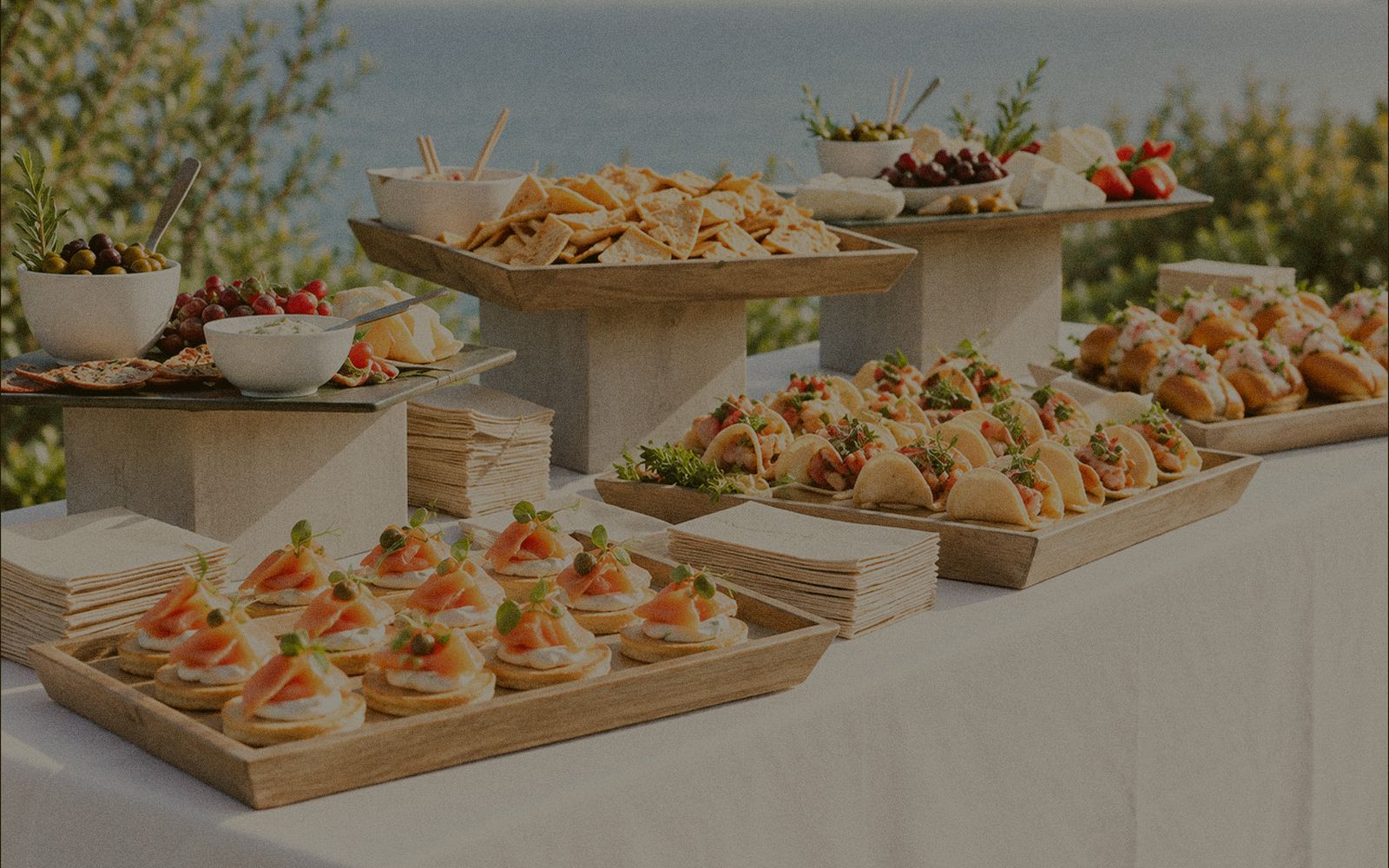 Buffet de pièces salées et plateaux en bois face à la mer